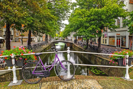 Lila Fahrrad steht auf einer Brücke in der Altstadt von Delft