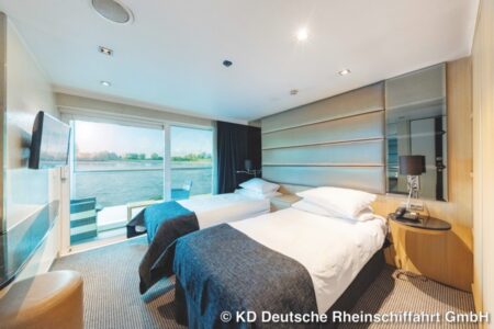 eine Doppelkabine auf einem Schiff mit einem Großen Fenster und Stühlen