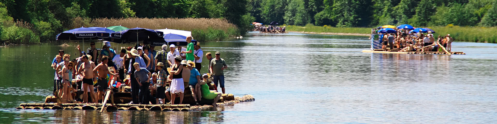 Mehre Flöße fahren auf der Isar in München