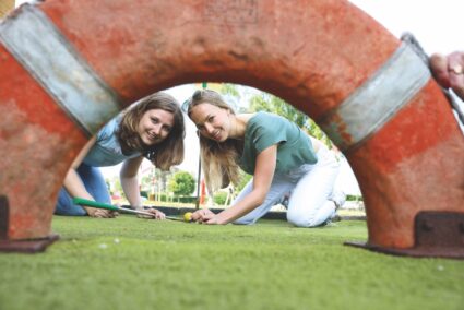 Personen spielen Minigolf