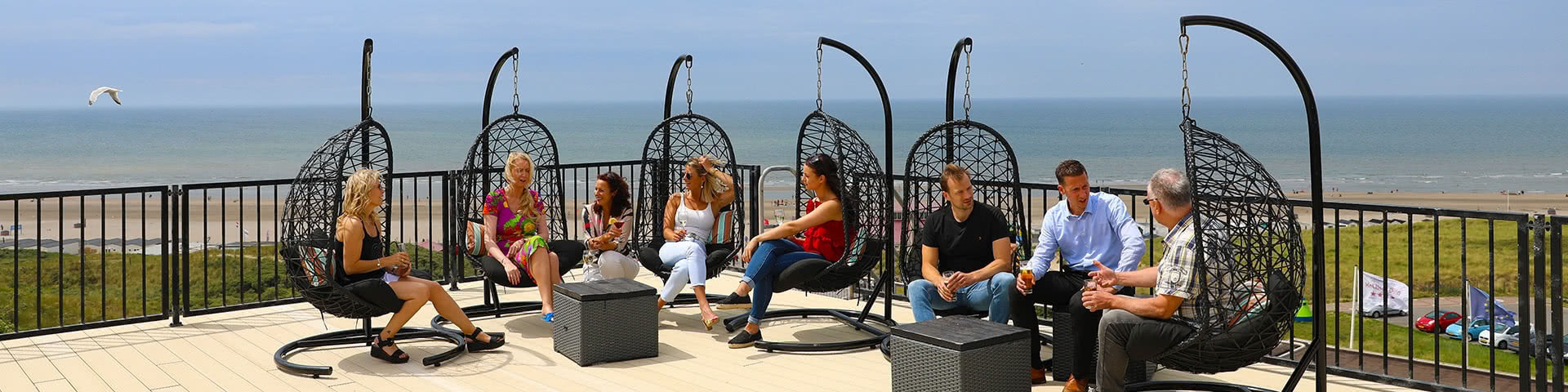 Gruppe sitzt zusammen auf einer Terasse in Wijk aan Zee